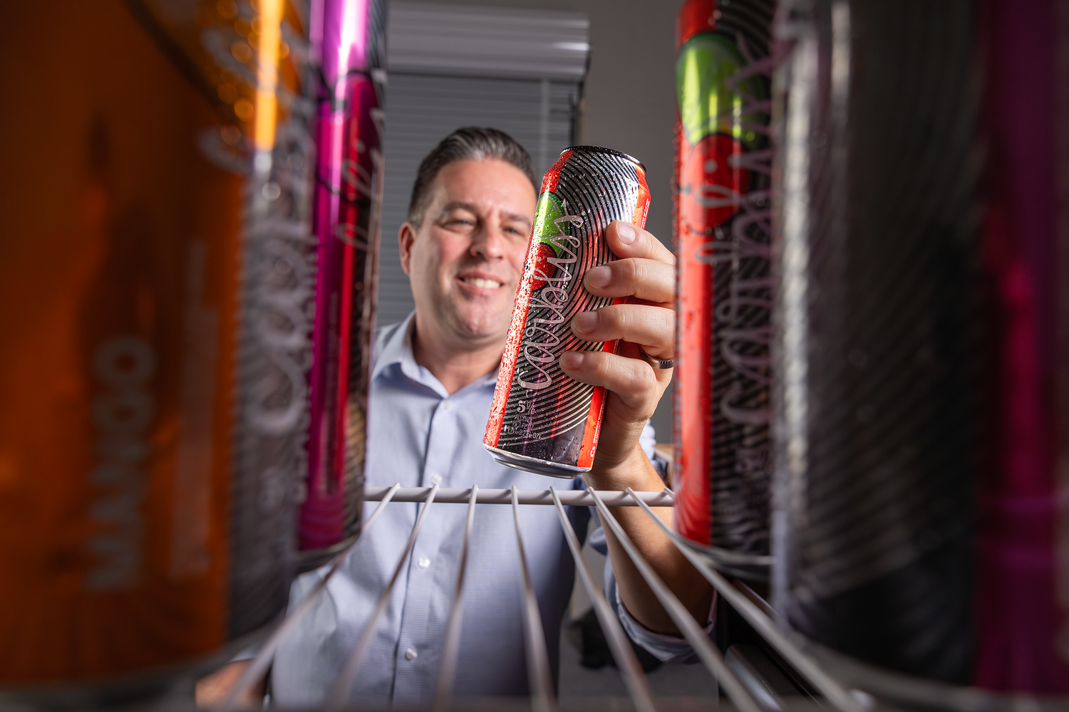 Man grabbing a Carbliss Cocktails Cherry Limeade out of the refrigerator